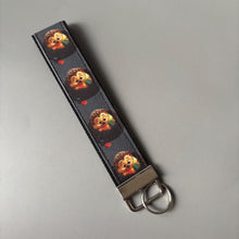 Load image into Gallery viewer, Reading hedgehog wristlet keychain. Hedgehog keyring. Hedgehog wrist strap keyring.